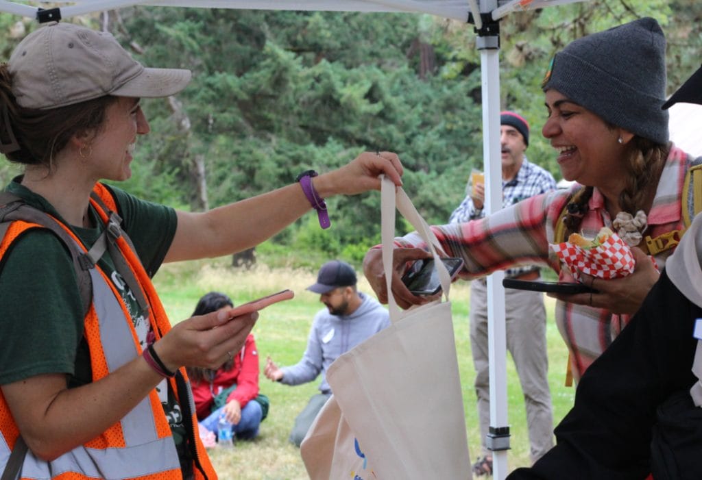 A person hands a bag to another