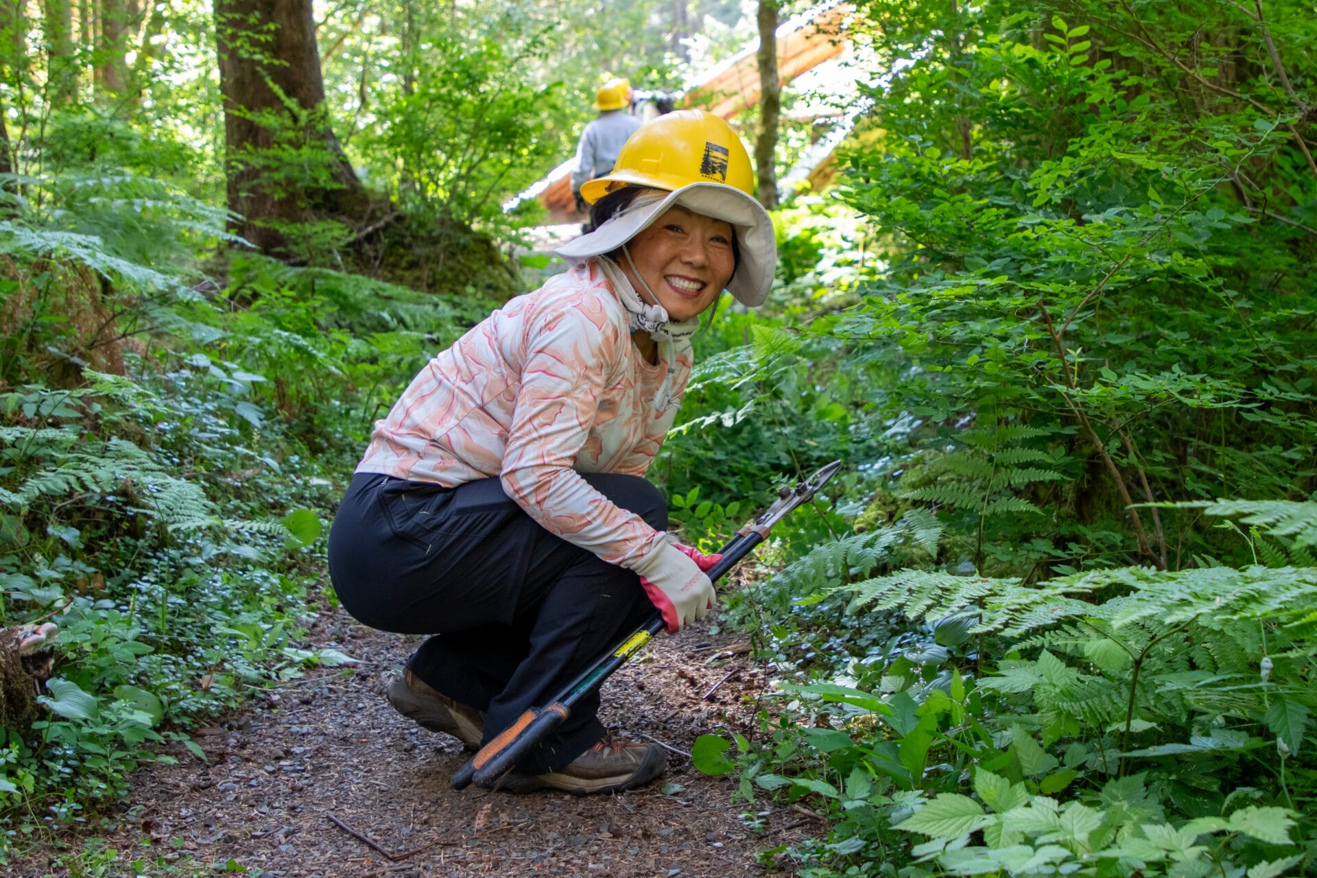 Volunteer brushing back an overgrown trail in the Middle Fork Snoqualmie Valley