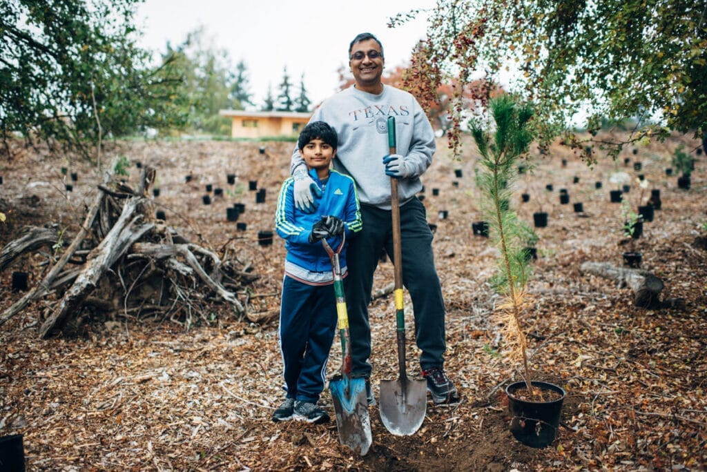 A father and his son volunteer to plant trees in a habitat